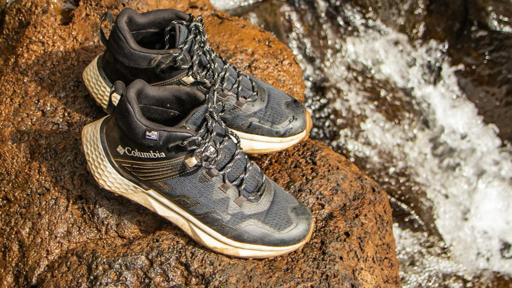 Dusty hiking boots and water on a red rock ledge in Sedona, Arizona.